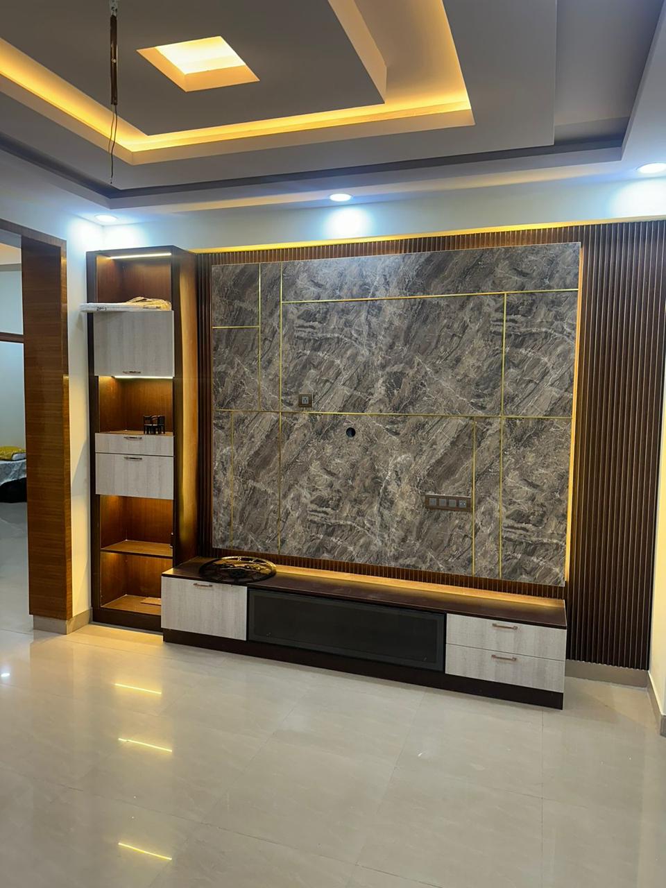 Finished living room with marble TV panel fluted wood wall and warm ceiling lights