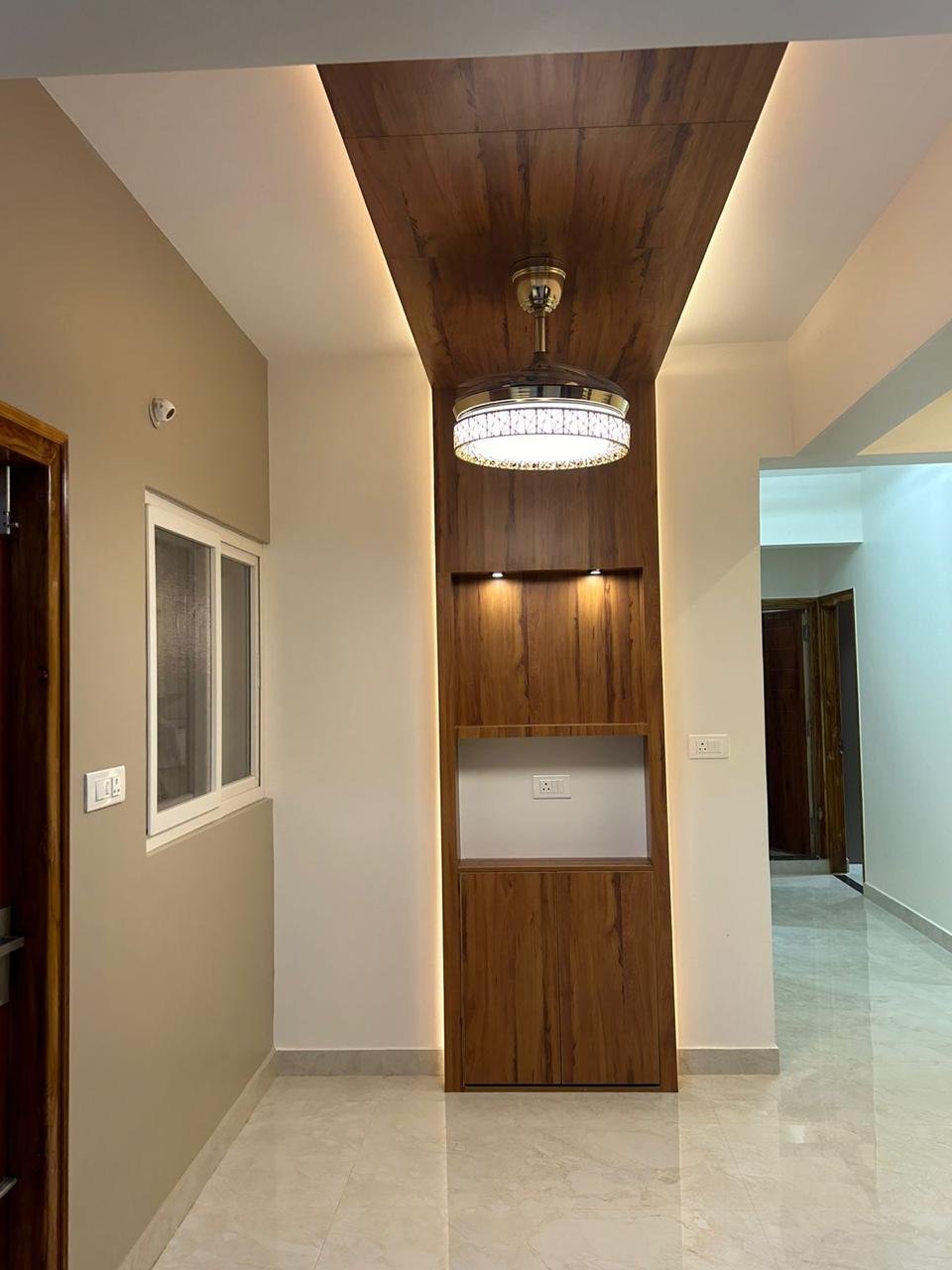Finished hallway with vertical wood panel niche warm backlighting and decorative ceiling light